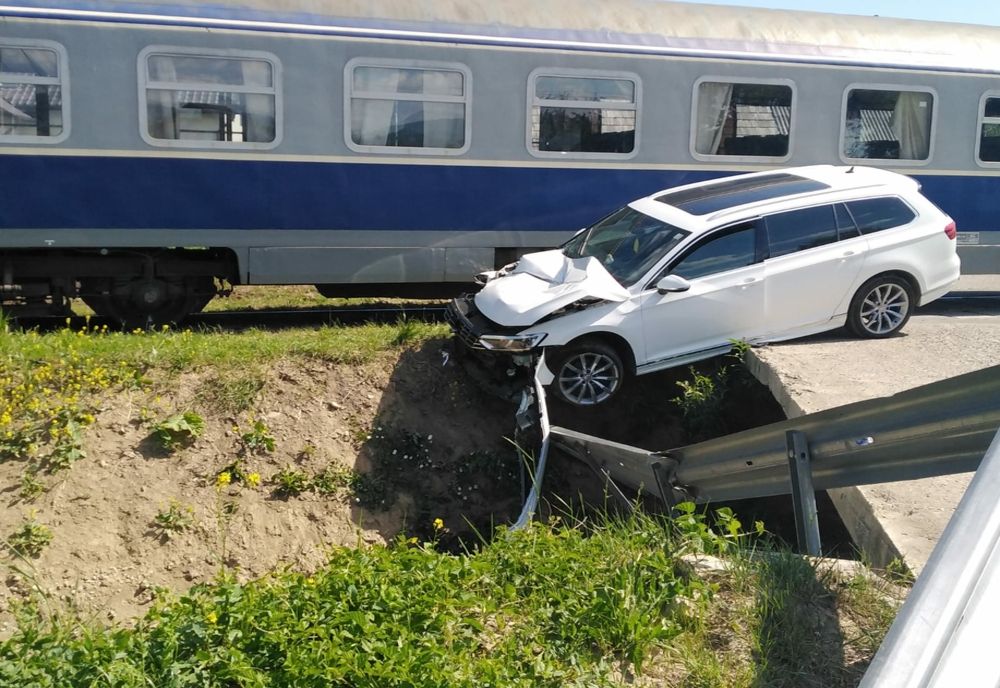FOTO/ A scăpat ca prin urechile acului după ce mașina în acre se afla a fost lovită de tren